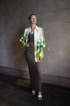 Image featuring a woman wearing the silk twill Constance top by Alemais with a button front and a split down the center back with ties in an allover floral print.