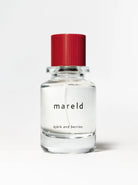 Image of BJORK AND BERRIES MARELD  luxury personal fragrance eau de parfum with notes of SALTED FIG BERGAMOT and TONKA WOOD in a Scandinavian minimalist design clear glass bottle and red lid