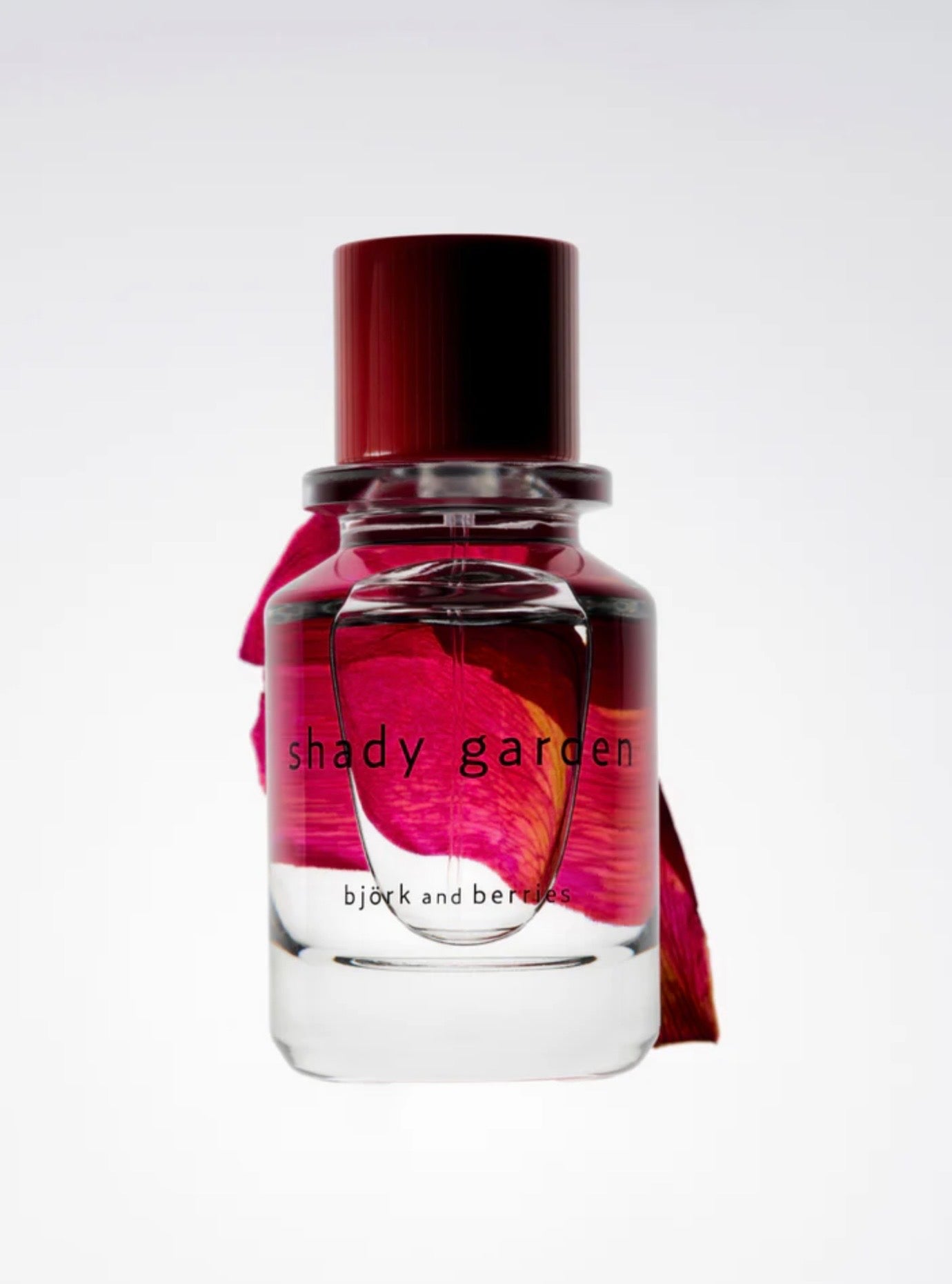 Image of BJORK AND BERRIES Shady Garden luxury personal fragrance eau de parfum with notes of Peony, Arctic Bramble and patchouli in a Scandinavian minimalist design clear glass bottle and red lid