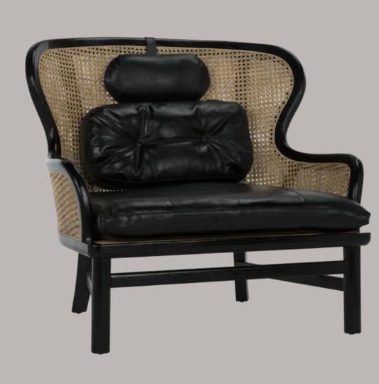 Image featuring a wide lounge black chair with natural caning and removable black leather seat cushion, bolster & headrest pillows.