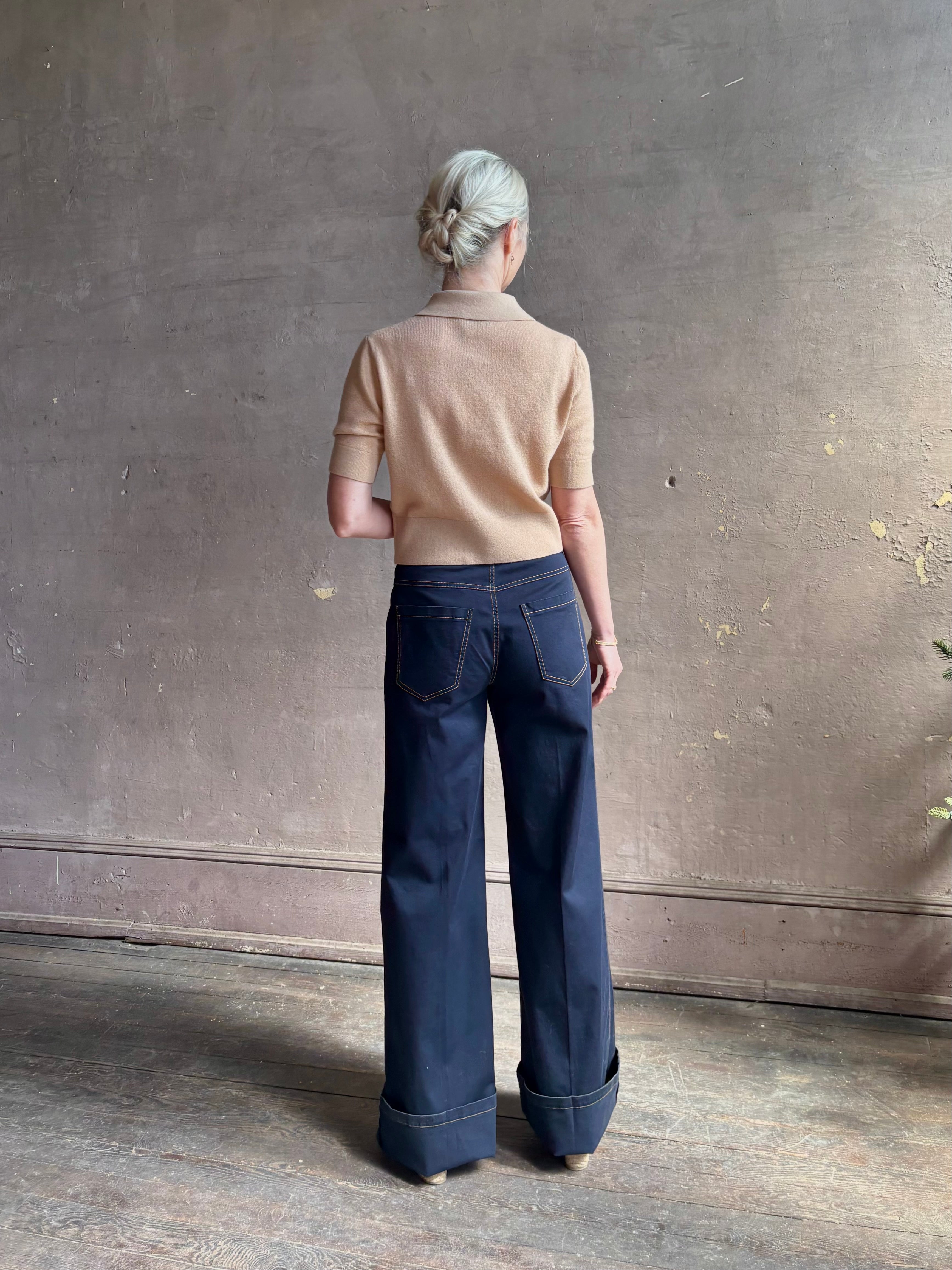 Mature woman wearing the European tailored Jane mid-rise Pant from Callas rendered in a timeless navy and crafted from a stretchy cotton blend featuring yellow stitching, a clean flat front and flattering back pockets