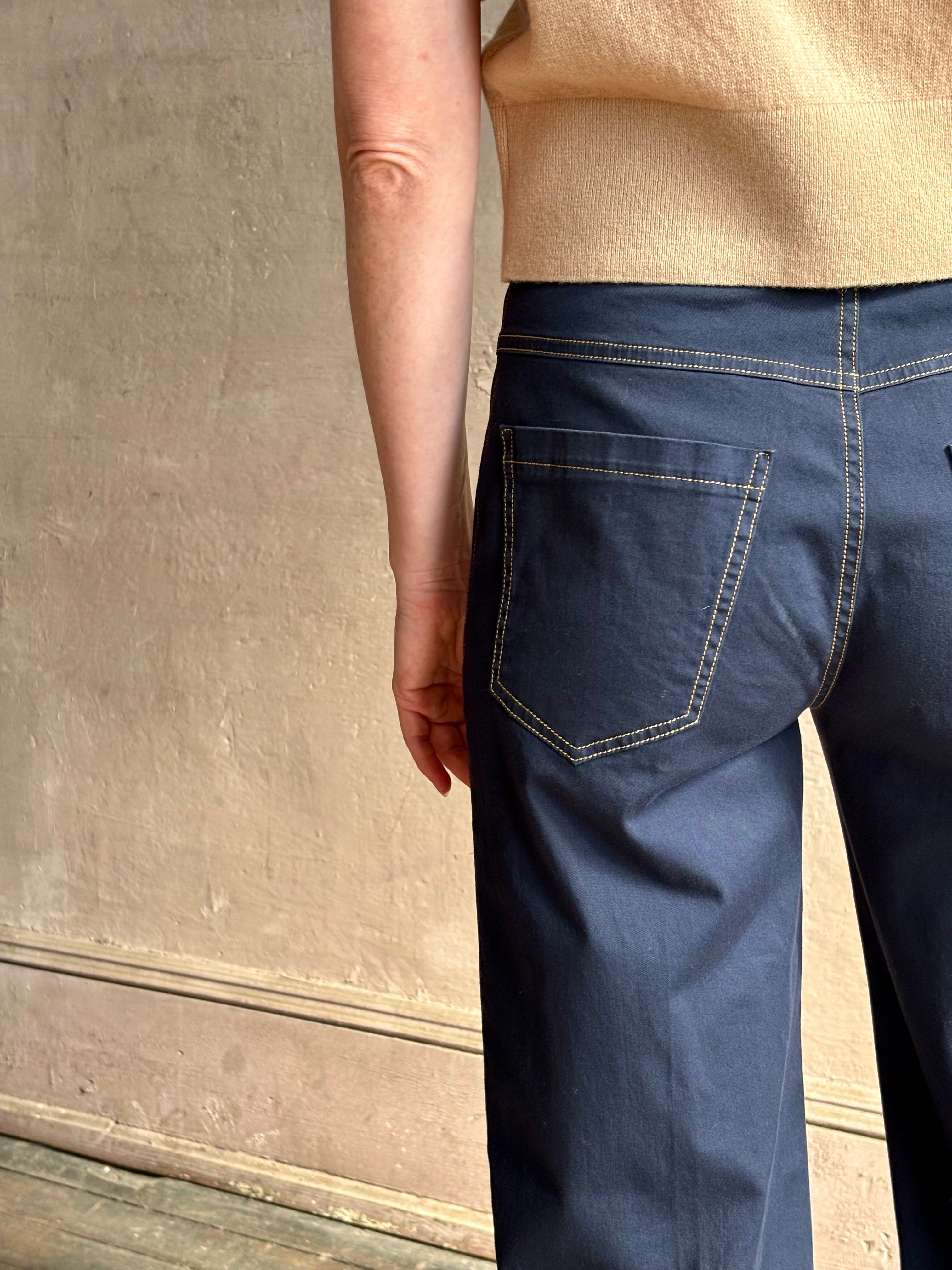 Mature woman wearing the European tailored Jane mid-rise Pant from Callas rendered in a timeless navy and crafted from a stretchy cotton blend featuring yellow stitching, a clean flat front and flattering back pockets
