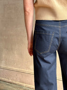 Mature woman wearing the European tailored Jane mid-rise Pant from Callas rendered in a timeless navy and crafted from a stretchy cotton blend featuring yellow stitching, a clean flat front and flattering back pockets