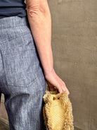 Mature woman wearing Italian designer Tonne trouser from Callas rendered in a dark indigo and crafted from a viscose, polyester, and linen blend with beautiful fluid draping and effortless versitility similar to denim