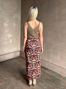 Mature woman wearing Cara Cara blaze long pencil skirt with a brown pink and beige botanical damask pattern 