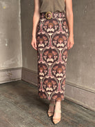 Mature woman wearing Cara Cara blaze long pencil skirt with a brown pink and beige botanical damask pattern 