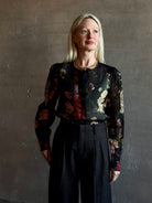 Mature woman wearing Cara Cara Chili Blouse in Meadows Black linen-silk  crystal buttons Romantic dressmaker-quality statement blouse