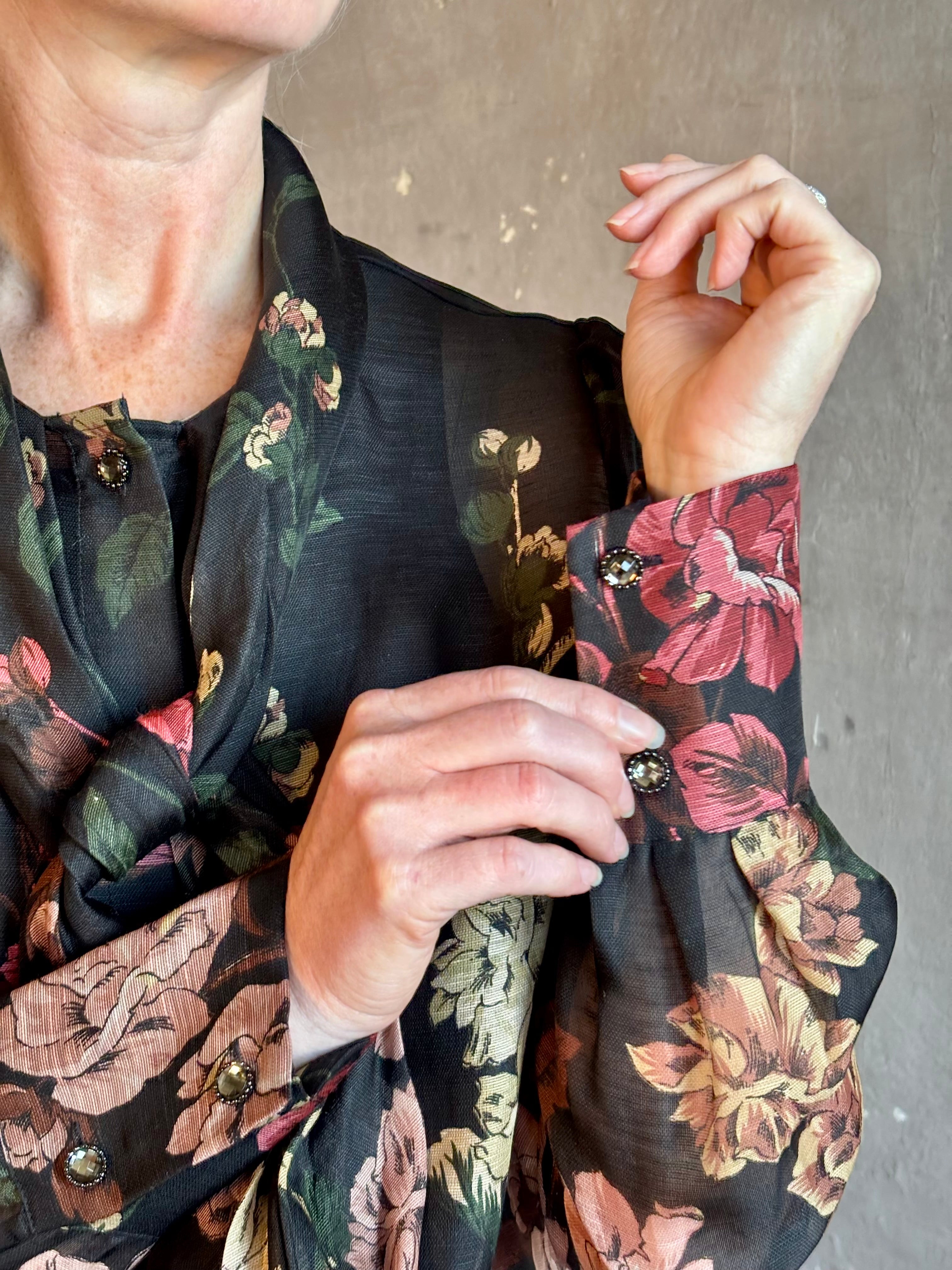 Mature woman wearing Cara Cara's Chili Blouse in Meadows Black linen-silk pussycat bow and crystal buttons. 