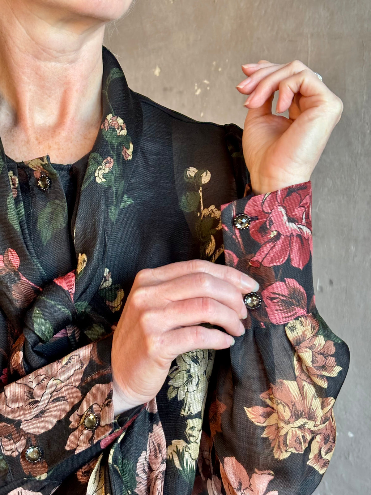 Mature woman wearing Cara Cara's Chili Blouse in Meadows Black linen-silk pussycat bow and crystal buttons. 