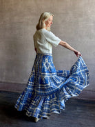 Mature woman wearing Emilia Skirt from Cara Cara rendered in the Hudson Scarf Sky blue and white print crafted from 100% cotton with shirred drop waist and ruffled tiered full skirt