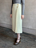 Image of woman wearing the premium cream tweed midi Luca skirt with faux wrap styling and textured fabrication by Cara Cara