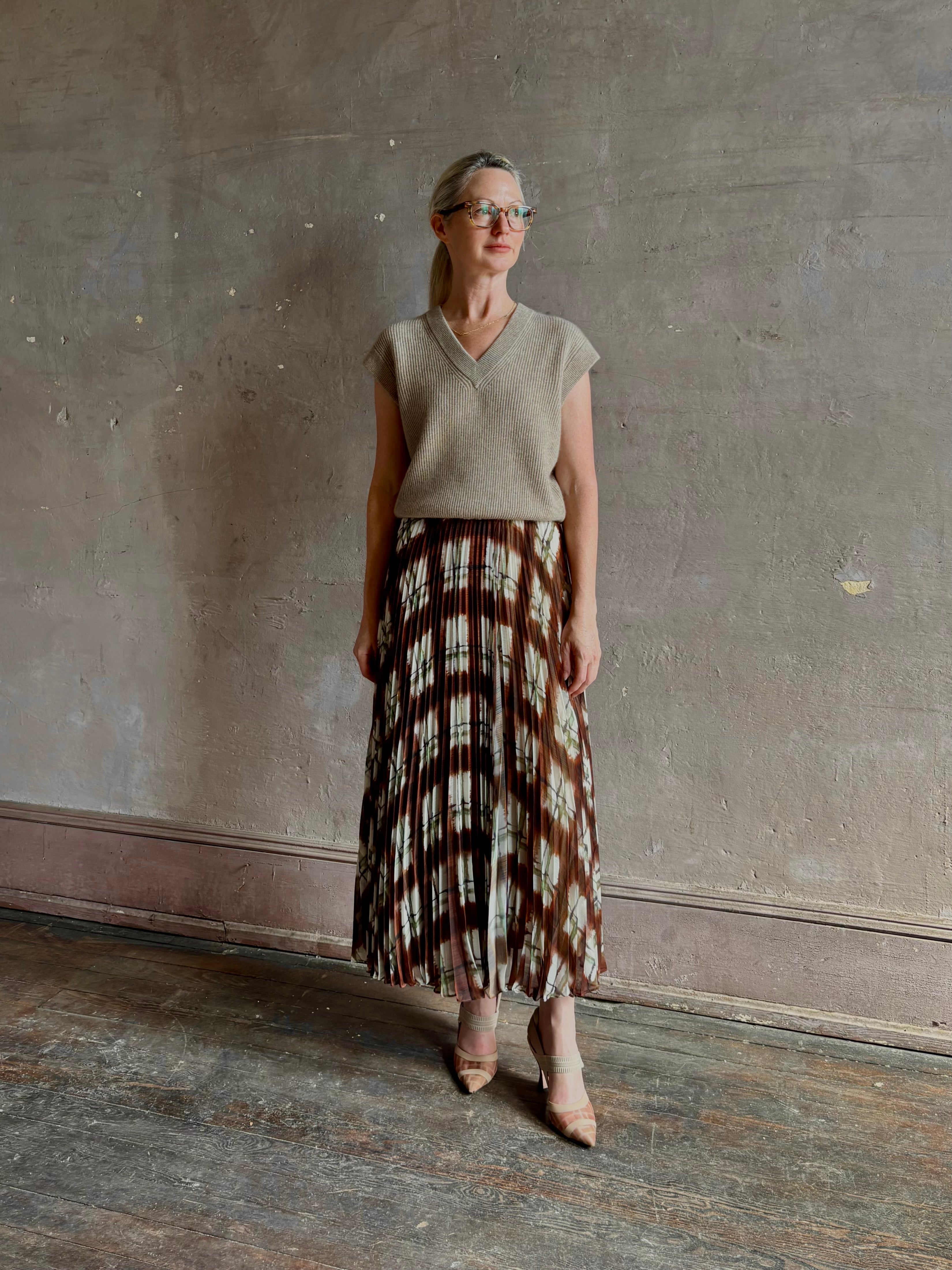 Mature woman wearing designer Cara Cara brown, cream, and green plaid patterned pleated otta maxi skirt