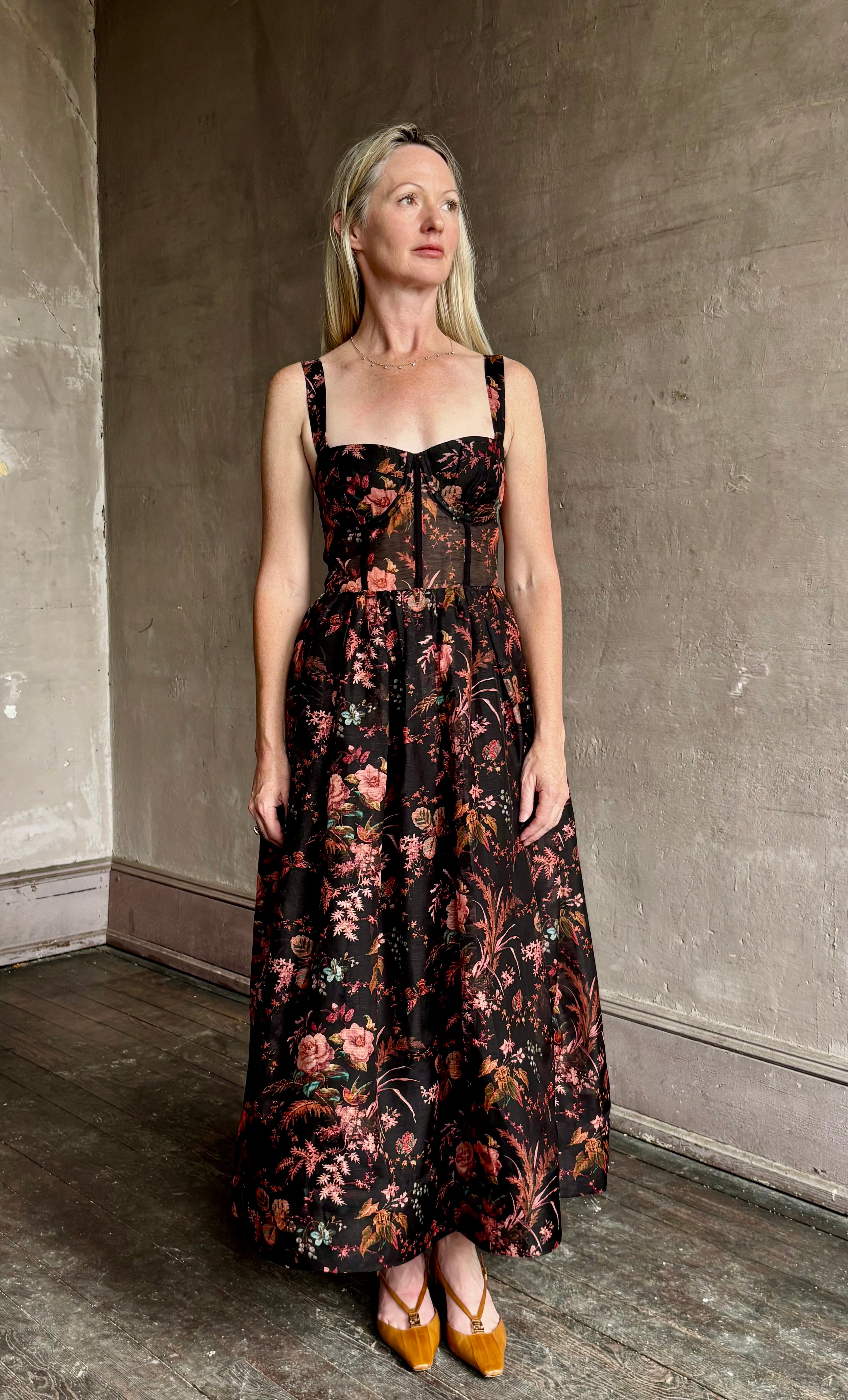Image of woman wearing premium linen-silk Pheobe midi dress by Cara Cara with expertly crafted unlined corset bodice in an elegant black floral print