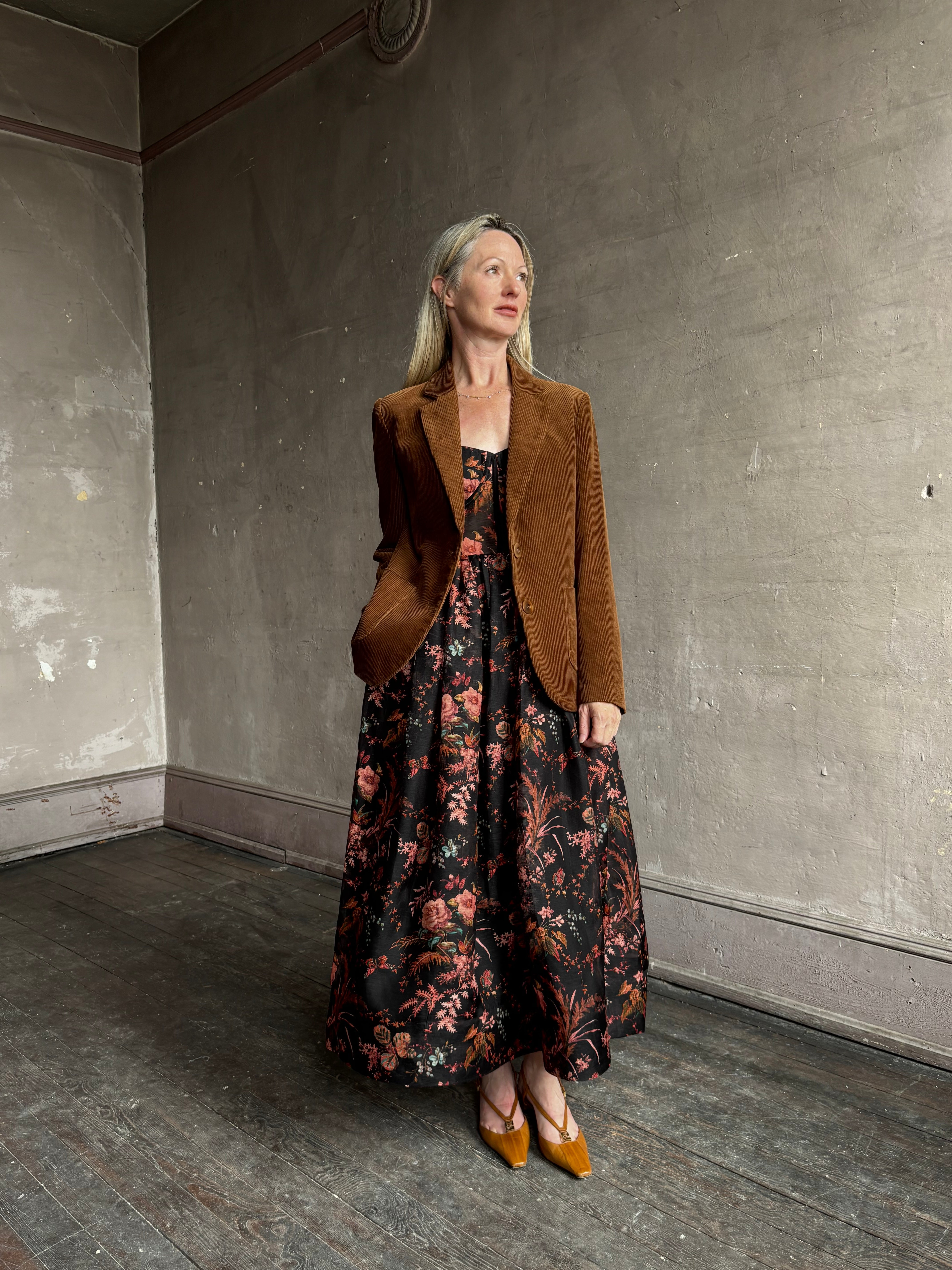 Image of woman wearing premium linen-silk Pheobe midi dress by Cara Cara with expertly crafted unlined corset bodice in an elegant black floral print