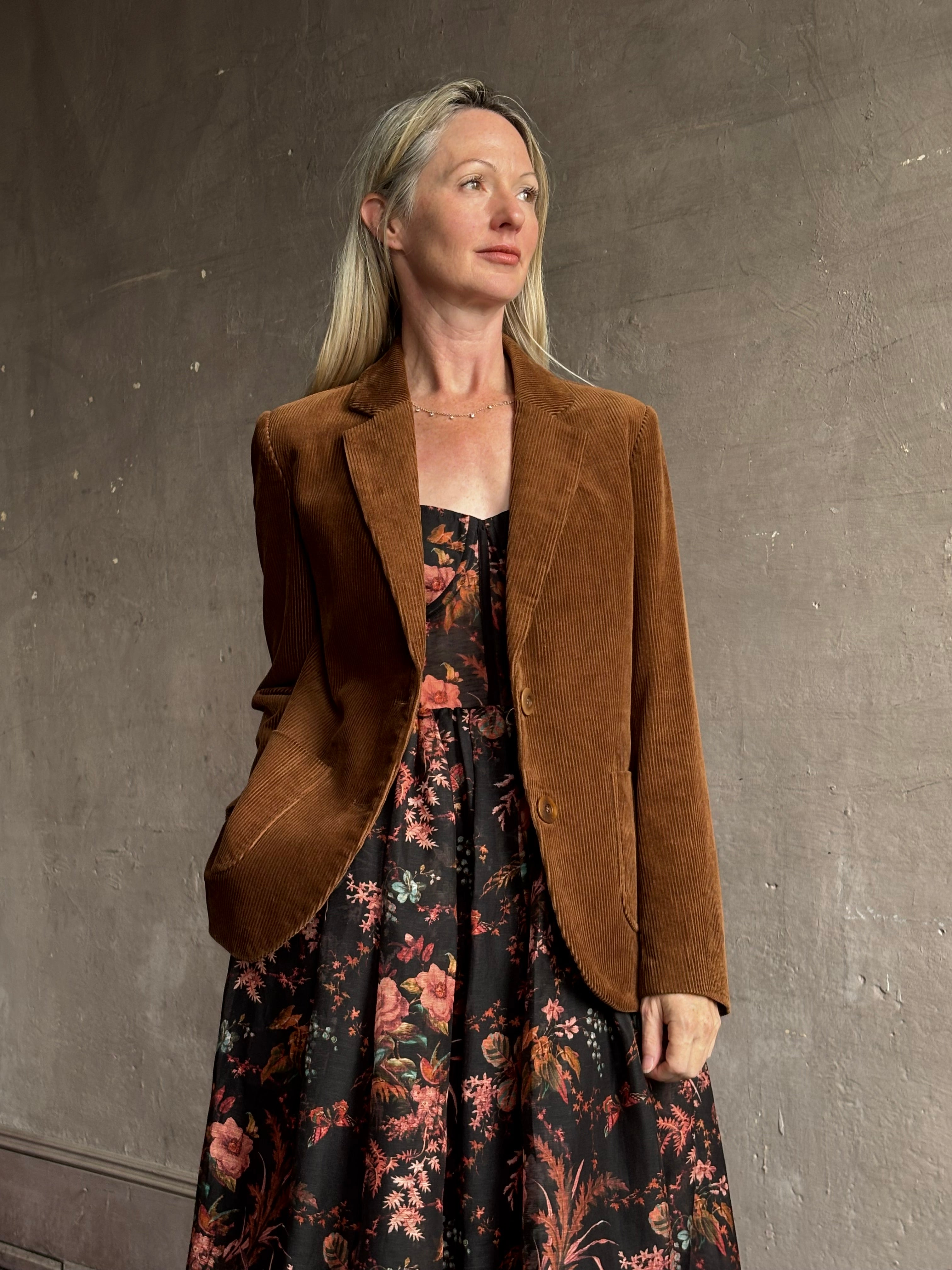 Image of woman wearing premium linen-silk Pheobe midi dress by Cara Cara with expertly crafted unlined corset bodice in an elegant black floral print