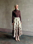 Mature woman wearing designer Cara Cara Tavira A-line Skirt in Castle Paisley Ivory heavy knit tonal paisley print understated everyday sophistication