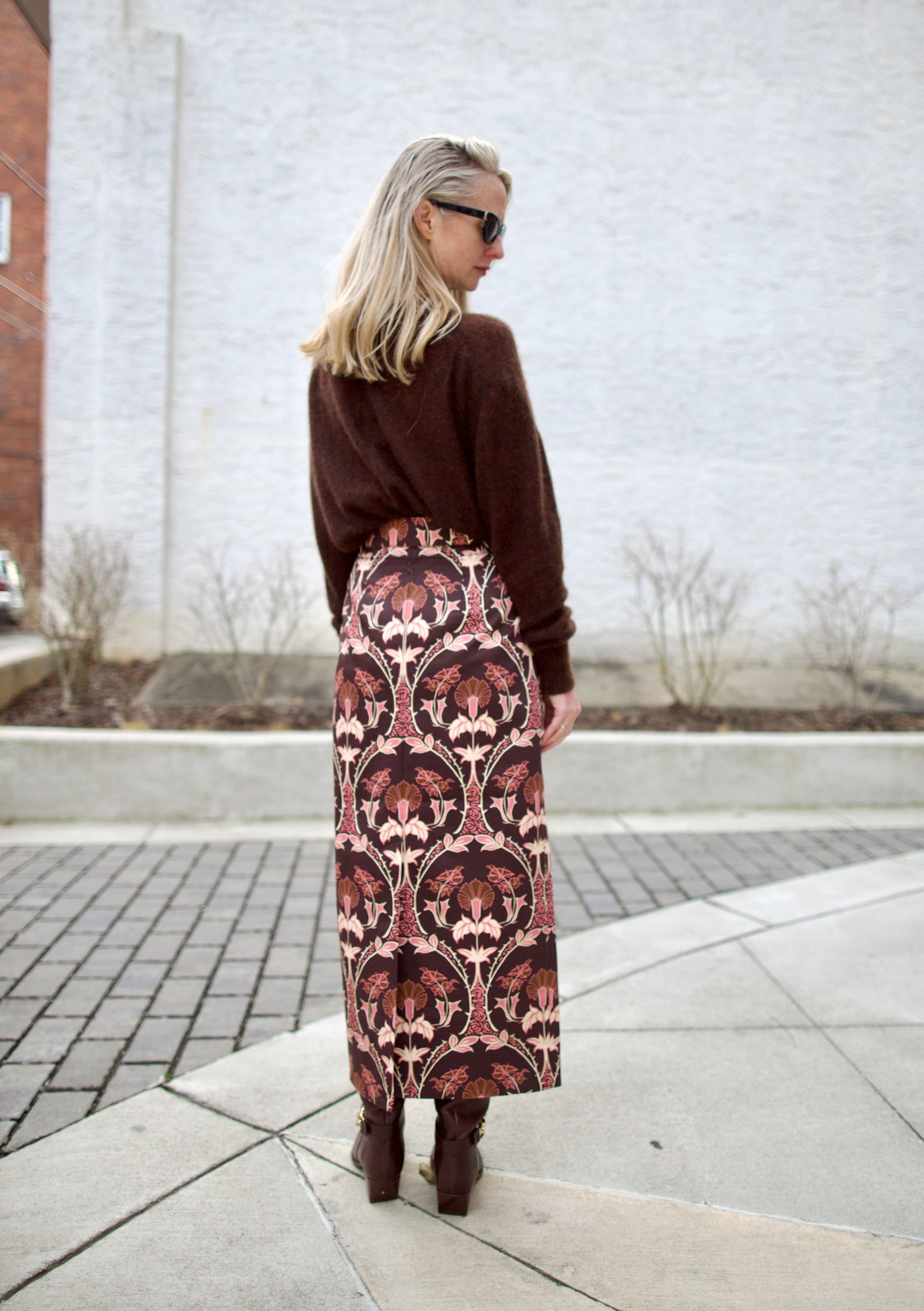 back image of a woman wearing the cara cara arcada skirt, ulla johnson willow boots and apiece apart tissue weight sweater