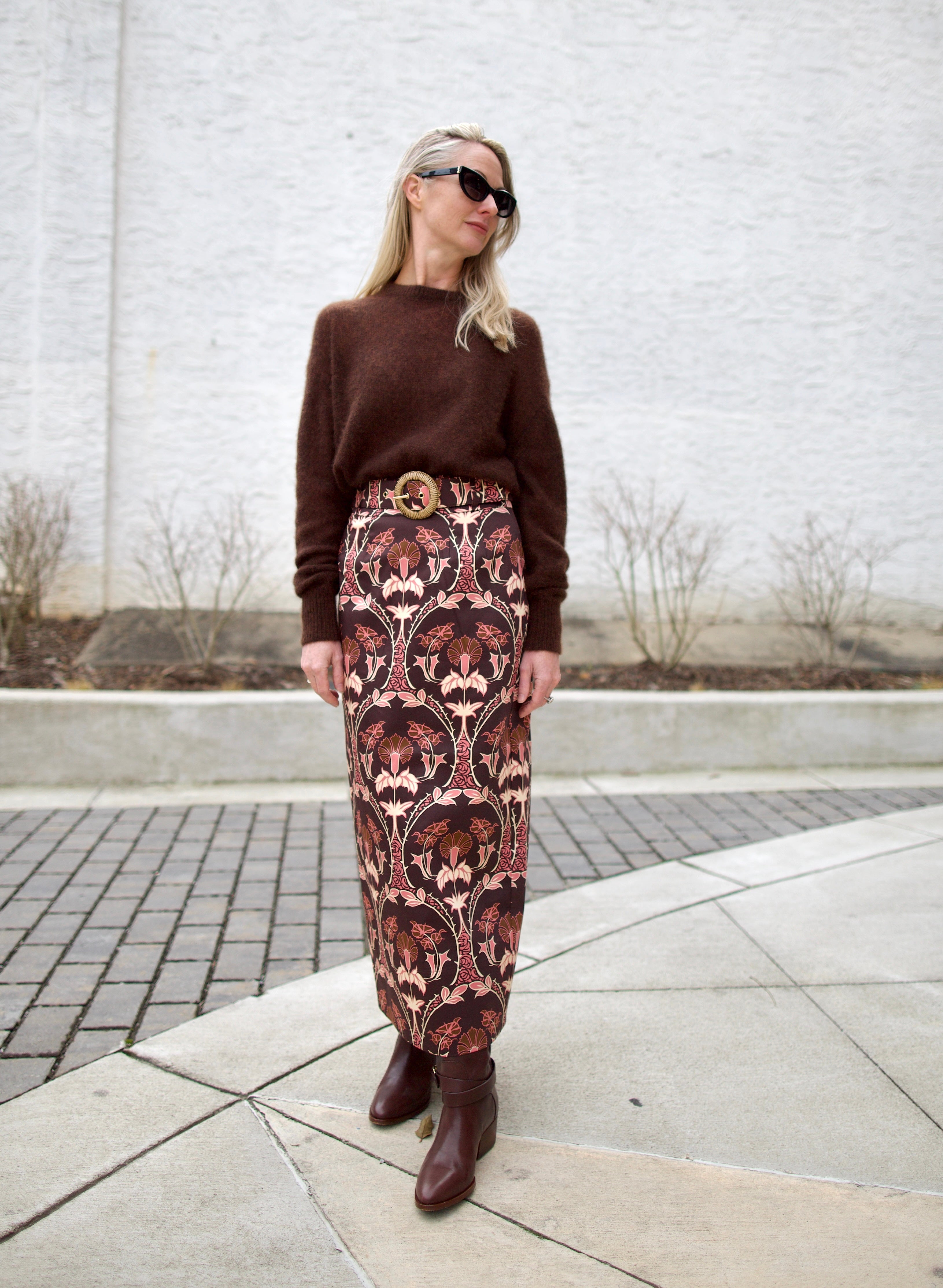 image of a woman wearing the cara cara arcada skirt, ulla johnson willow boots and apiece apart tissue weight sweater