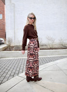 image of a woman wearing the cara cara arcada skirt, ulla johnson willow boots and apiece apart tissue weight sweater