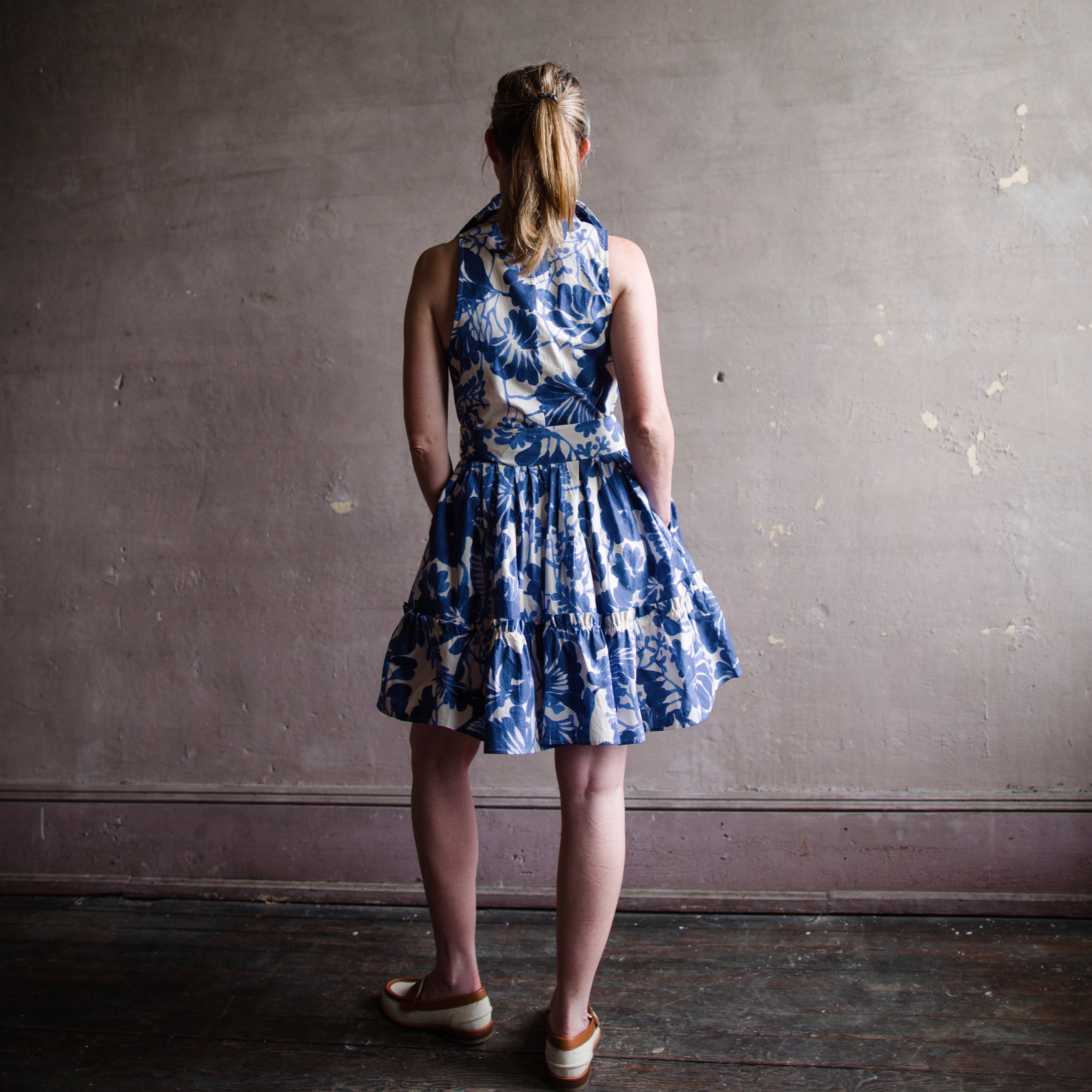 Image featuring a woman wearing the Cara Cara "Hannah" sleeveless shirtdress with a spread collar, button front, self-tie sash designed in a classic A-line silhouette.