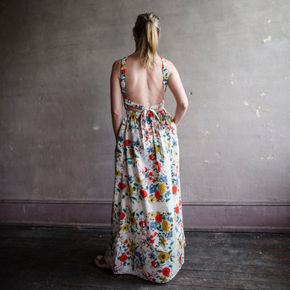 Image featuring a woman wearing the Colomba Dress from Cara Cara with a high scoop neckline and elastic waistband and open back.