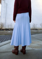 back image of a woman wearing the Cara Cara dara skirt with the Forte Forte sweater and Ulla Johnson Willow boots