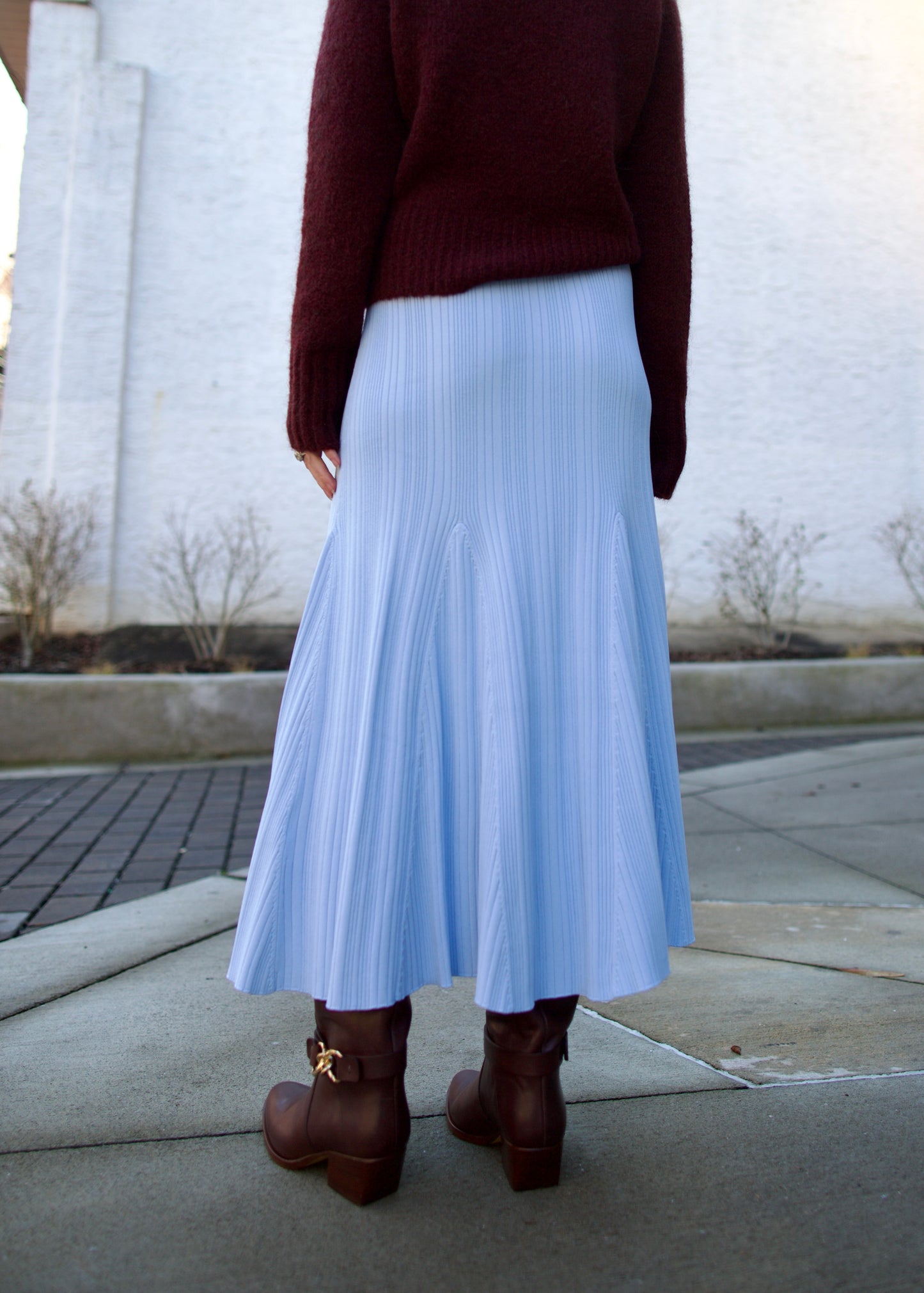 back image of a woman wearing the Cara Cara dara skirt with the Forte Forte sweater and Ulla Johnson Willow boots