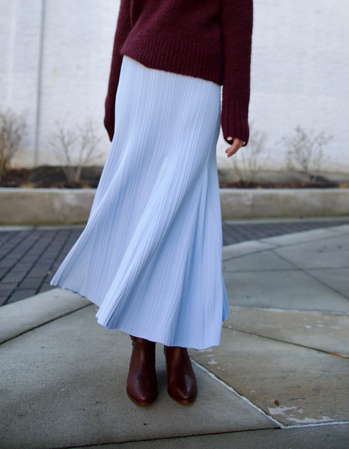 Mature woman wearing Cara Cara Dara Skirt in Sky Blue Knit construction elegant ribbed texture fit and flare sihlouette heavy fall knit weight