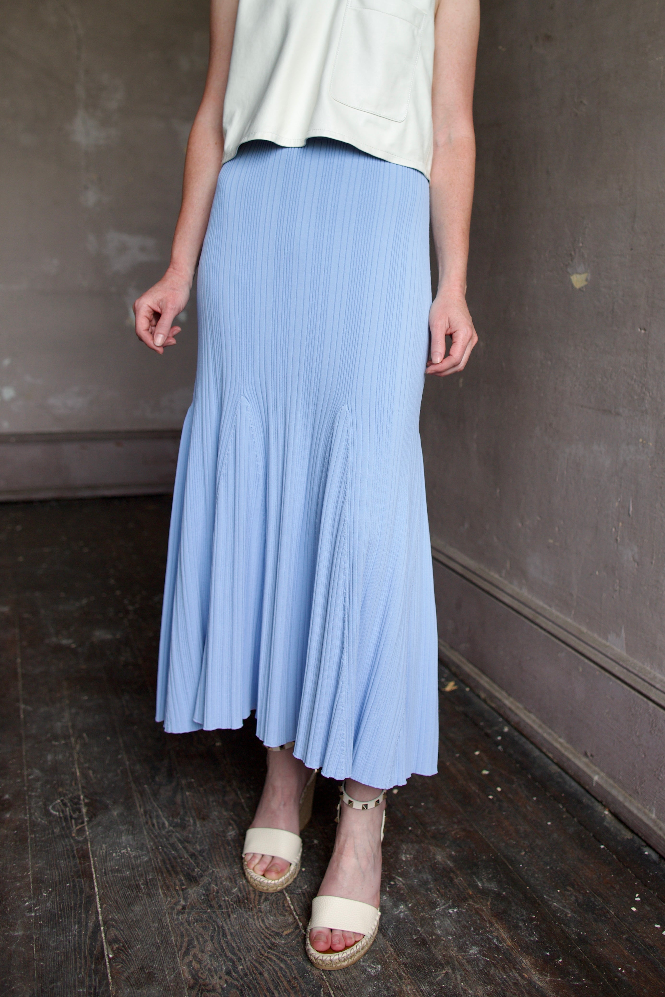 Mature woman wearing Cara Cara Dara Skirt in Sky Blue viscose-nylon-spandex construction with elegant ribbed texture, high-rise waist, and slightly flared hem