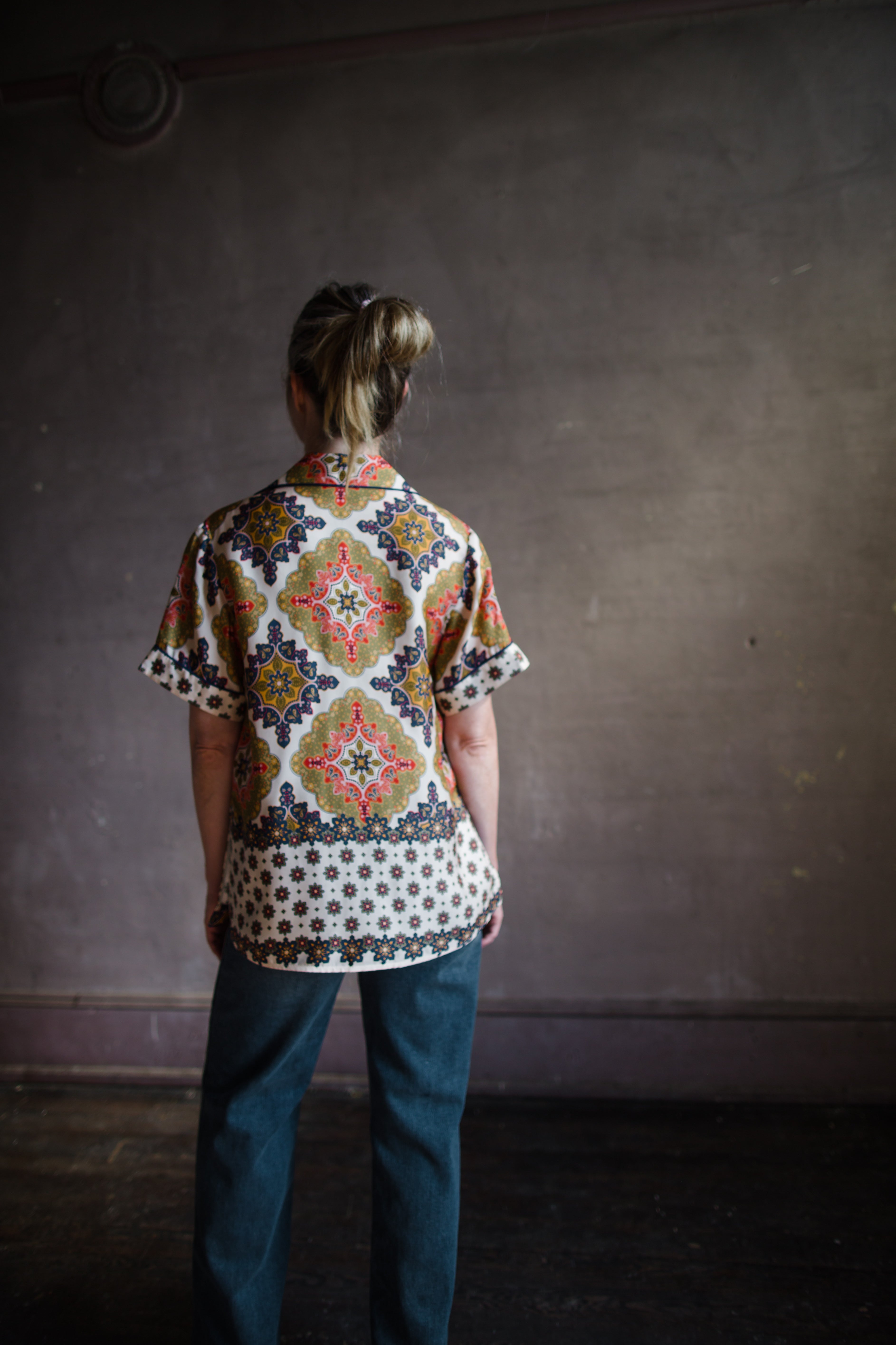 Image featuring a woman wearing the Portofino lightweight silk twill top from Cara Cara with a relaxed fit, contrast trim, pocket flaps and fusible collar in mandala Navy.