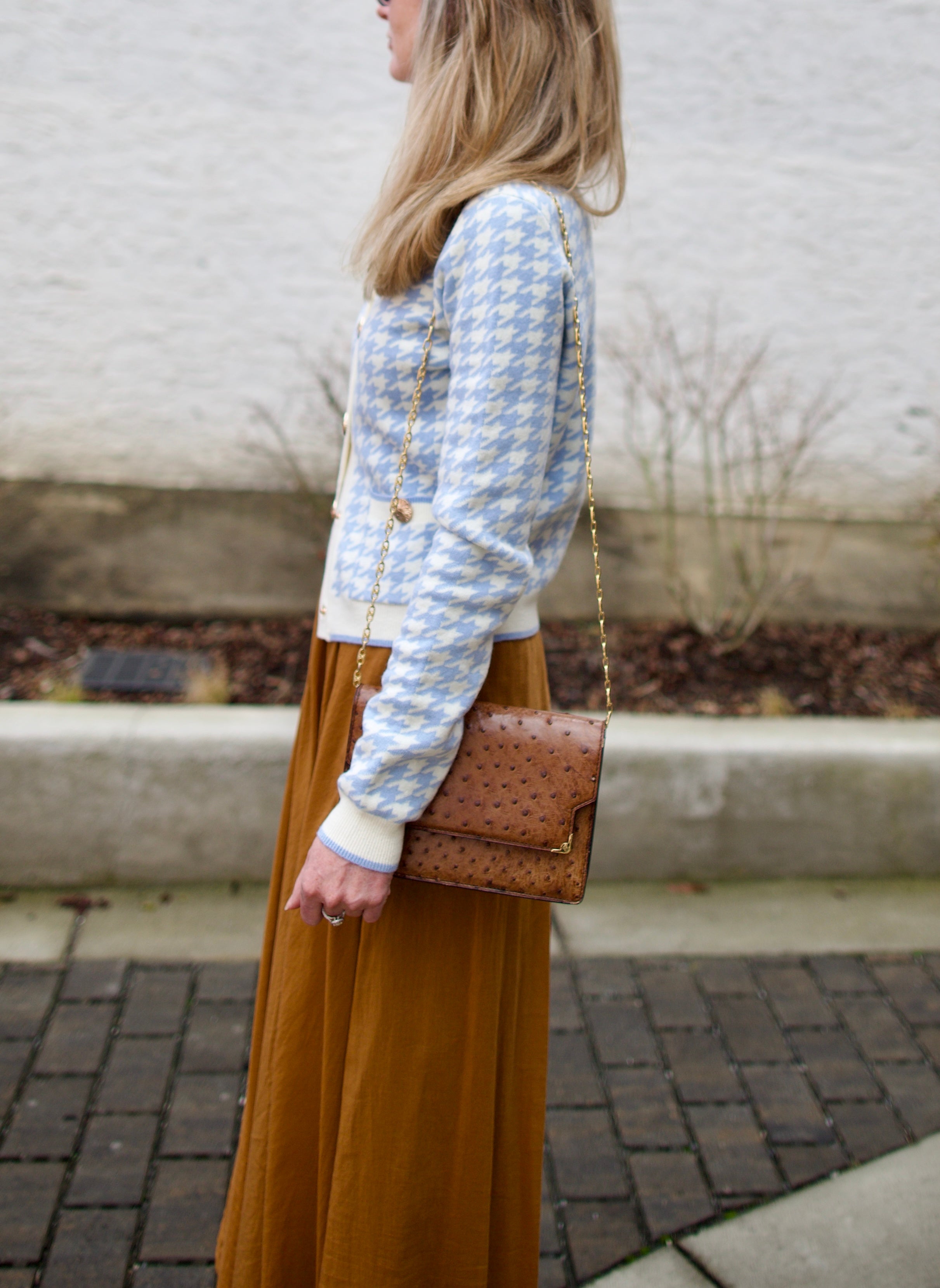 close up image of a woman wearing the Cara Cara priscilla cardigan and forte forte skirt.