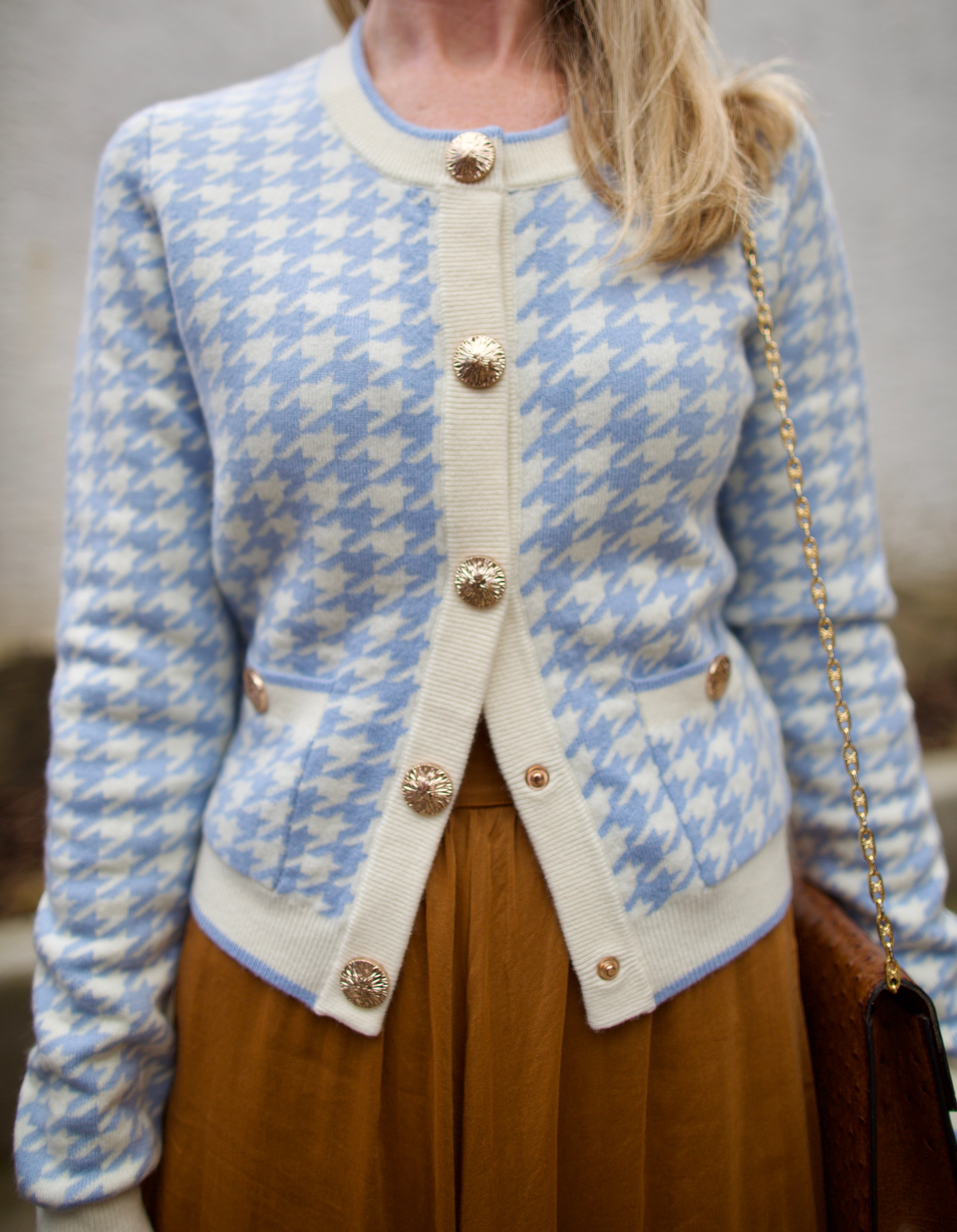 close up image of a woman wearing the Cara Cara priscilla cardigan and forte forte skirt.