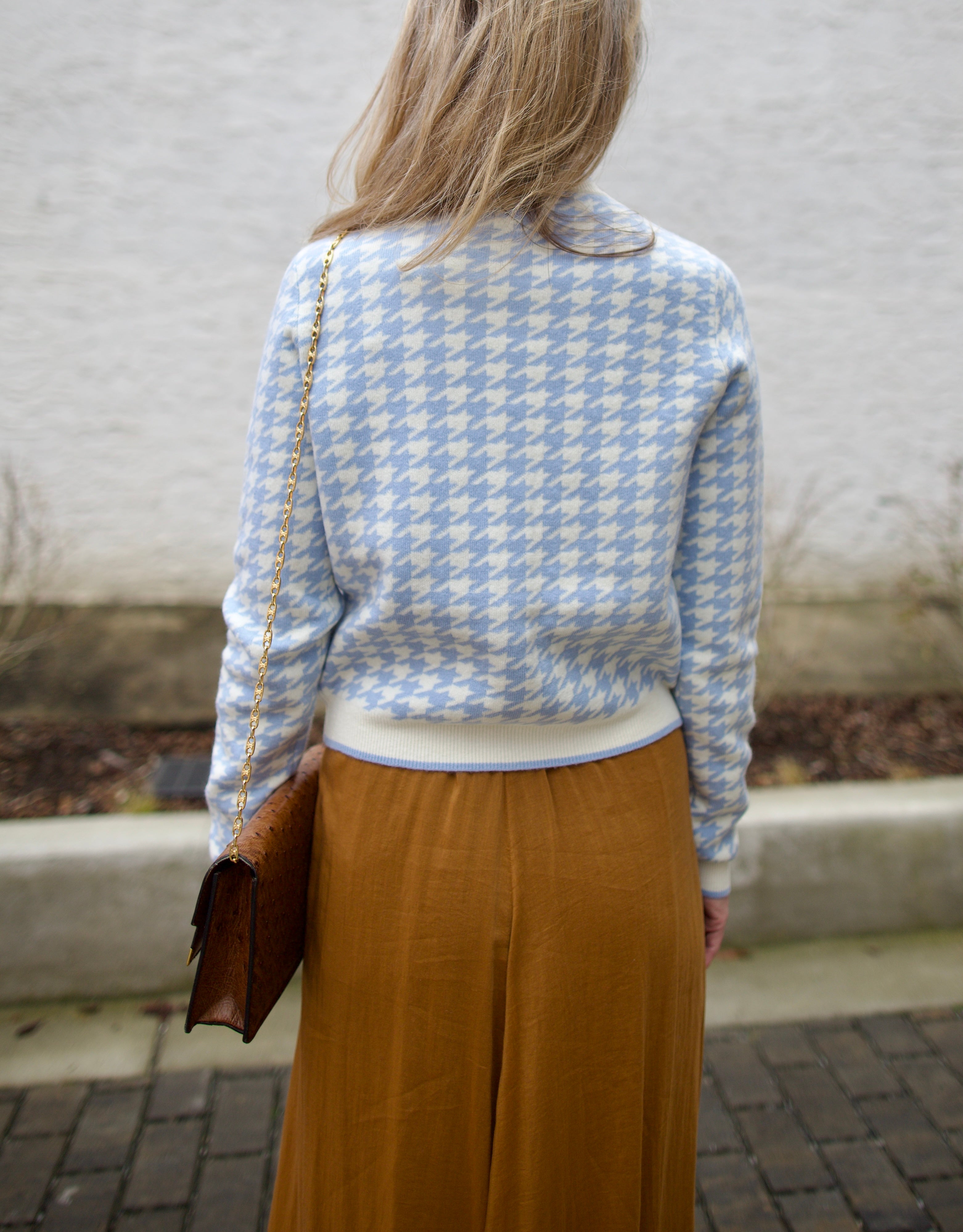 close up image of a woman wearing the Cara Cara priscilla cardigan and forte forte skirt.