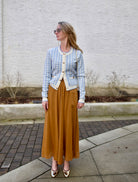 close up image of a woman wearing the Cara Cara priscilla cardigan and forte forte skirt with the Ulla Johnson ruffle pumps