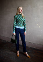 image of a woman wearing the cara cara suzie top, ulla johnson agnes jeans and mansur gavriel mini candy bag