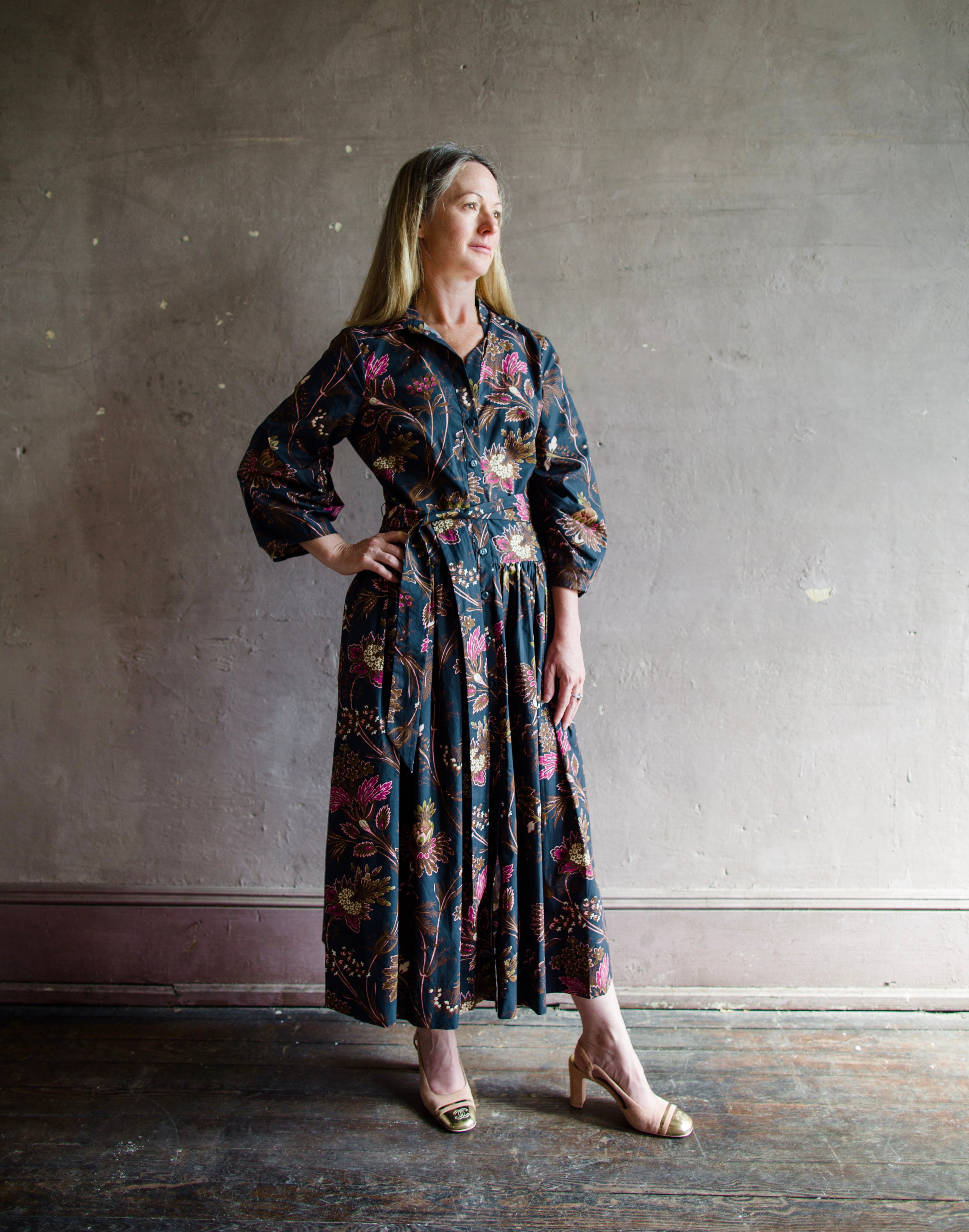 Image featuring a woman wearing the cotton Raya dress by Cara Cara with a collar and button front with full sleeves and flowy skirting in Blue Vintage Blossom print.