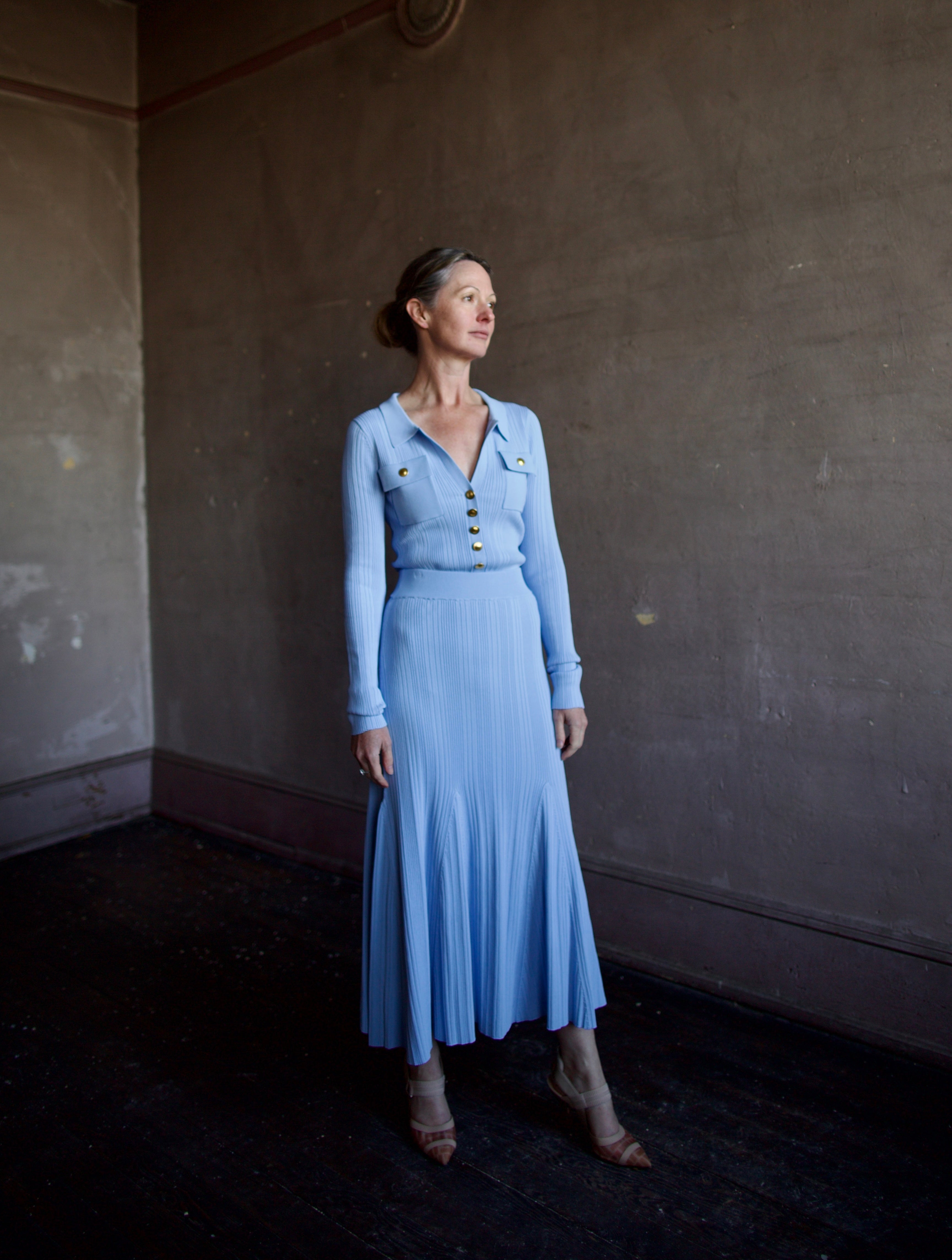 Mature woman wearing Cara Cara Belleport Top in Sky Blue photogaphed with matching knit skirt set