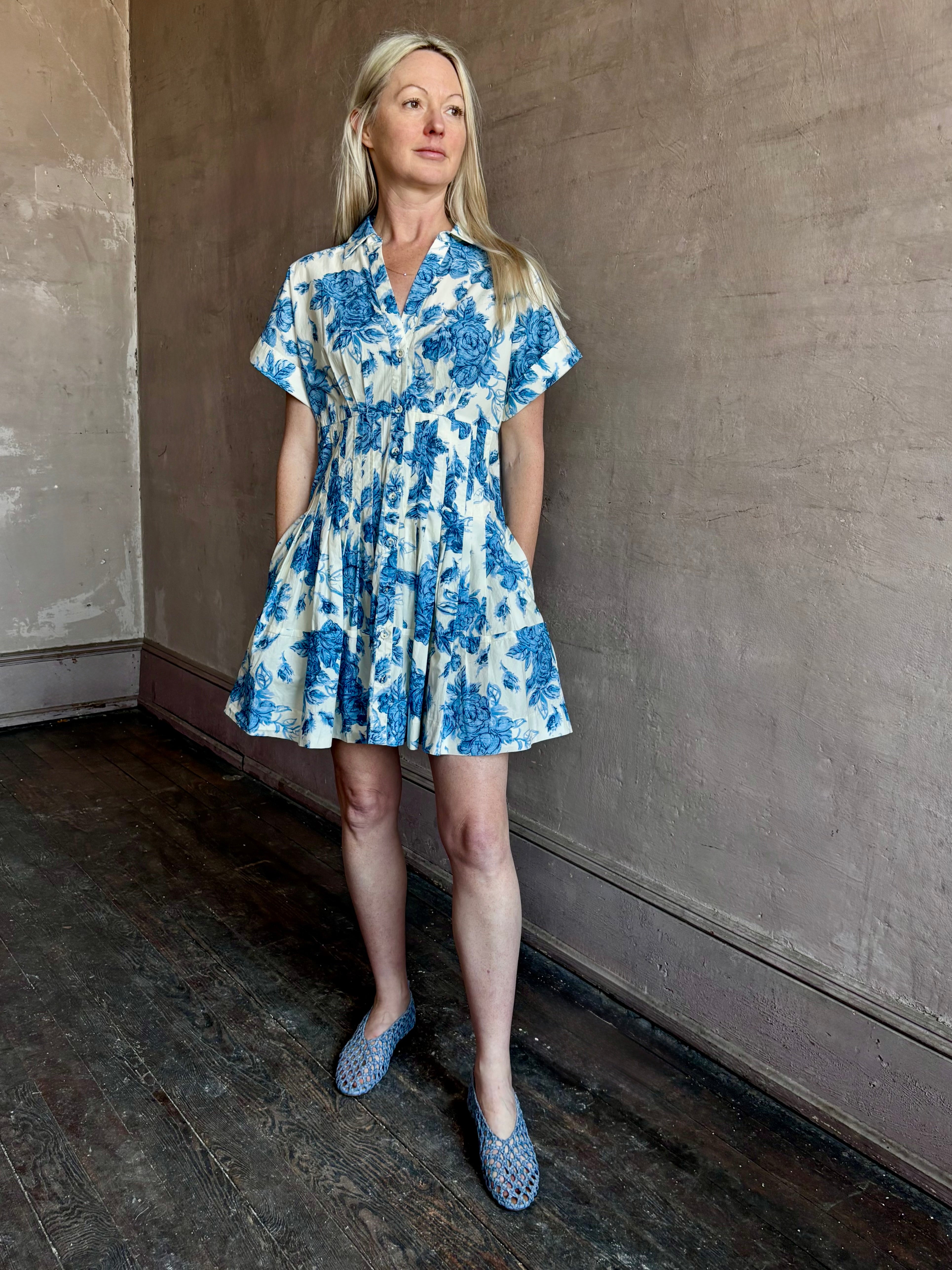 Image of woman wearing premium cotton poplin Cara Cara Nash Mini Dress in Tossed Floral Blue with v-neck short sleeves and pintucked waist detail