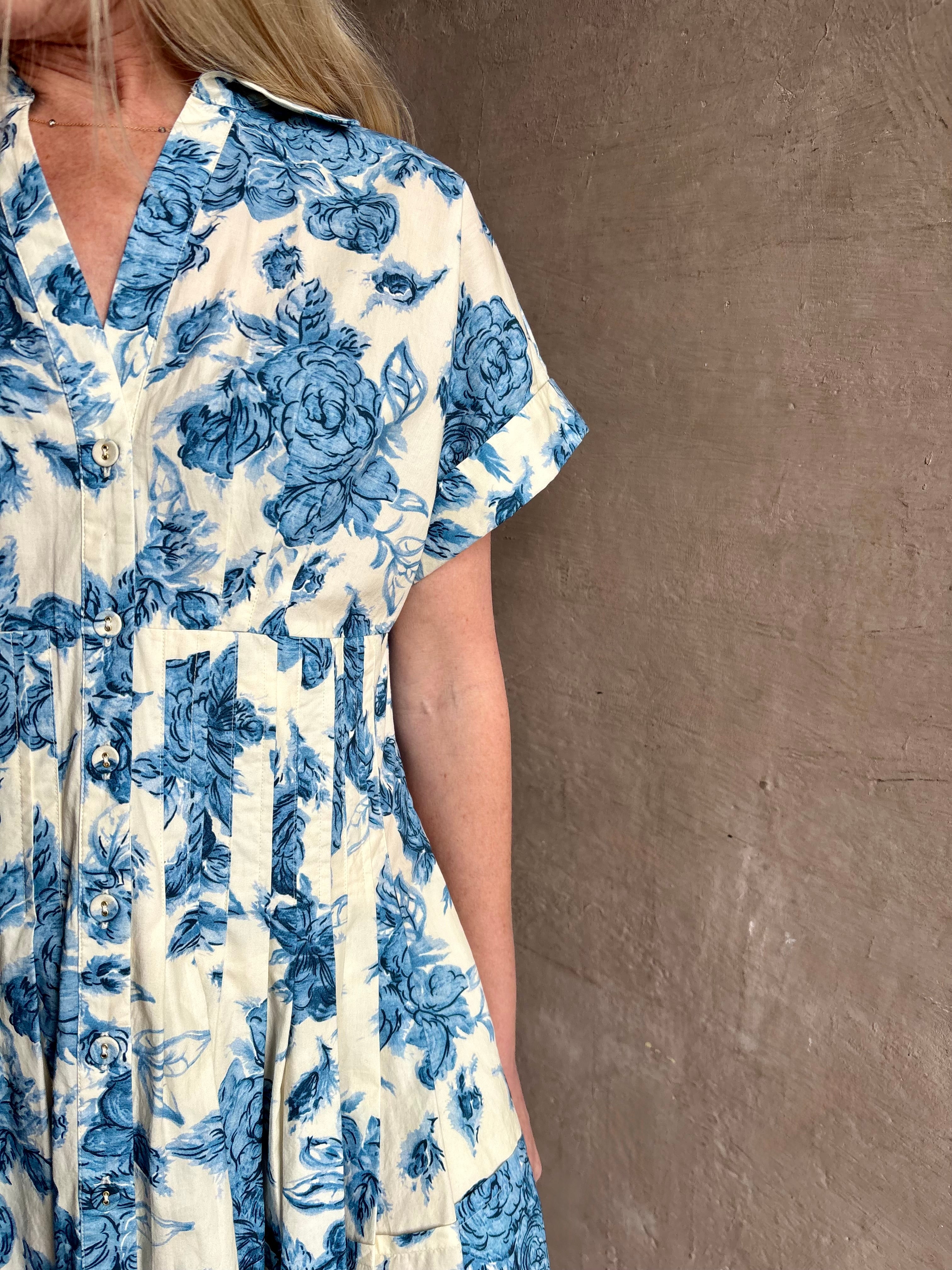 Image of woman wearing premium cotton poplin Cara Cara Nash Mini Dress in Tossed Floral Blue with v-neck short sleeves and pintucked waist detail