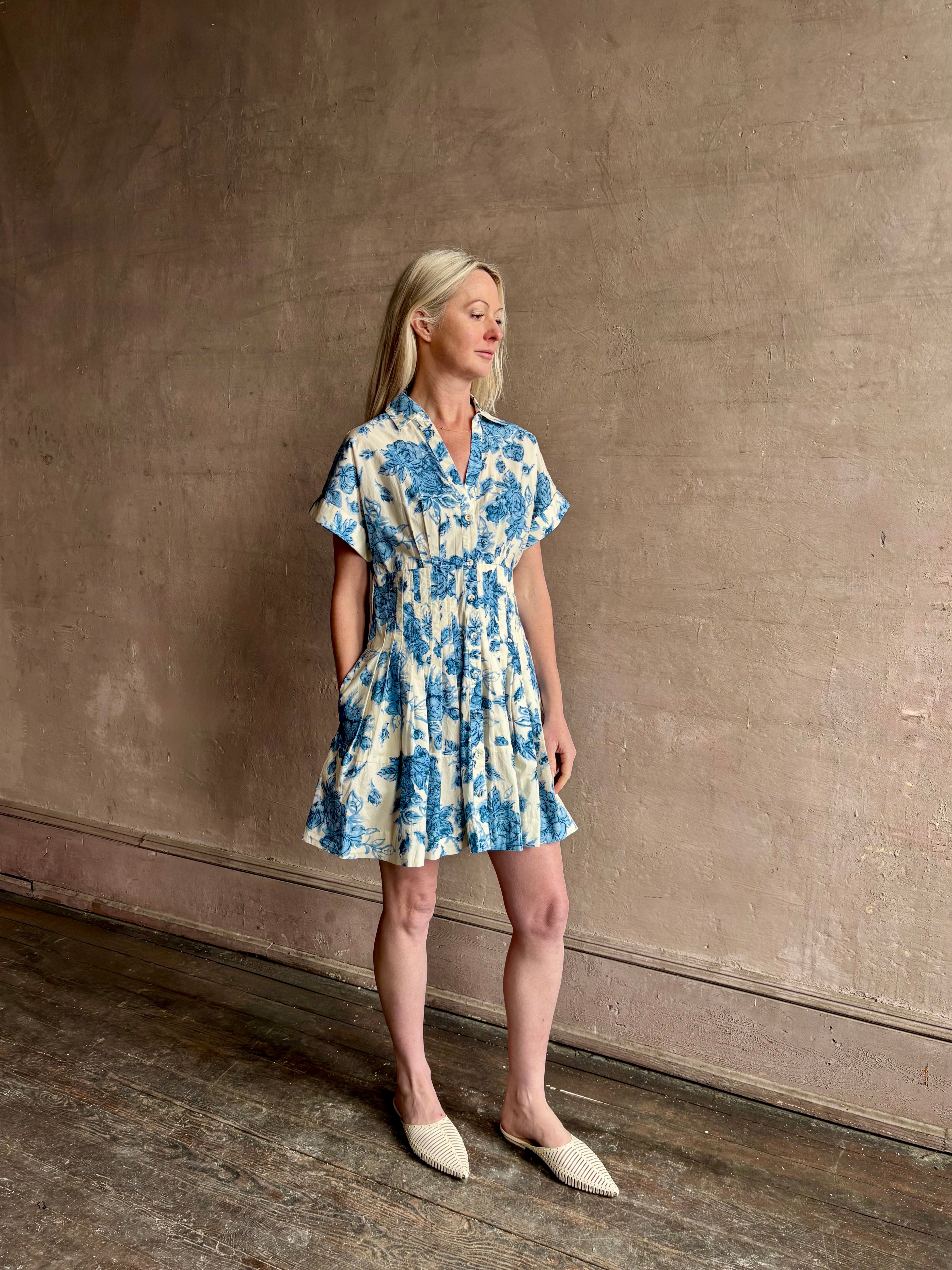 Image of woman wearing premium cotton poplin Cara Cara Nash Mini Dress in Tossed Floral Blue with v-neck short sleeves and pintucked waist detail