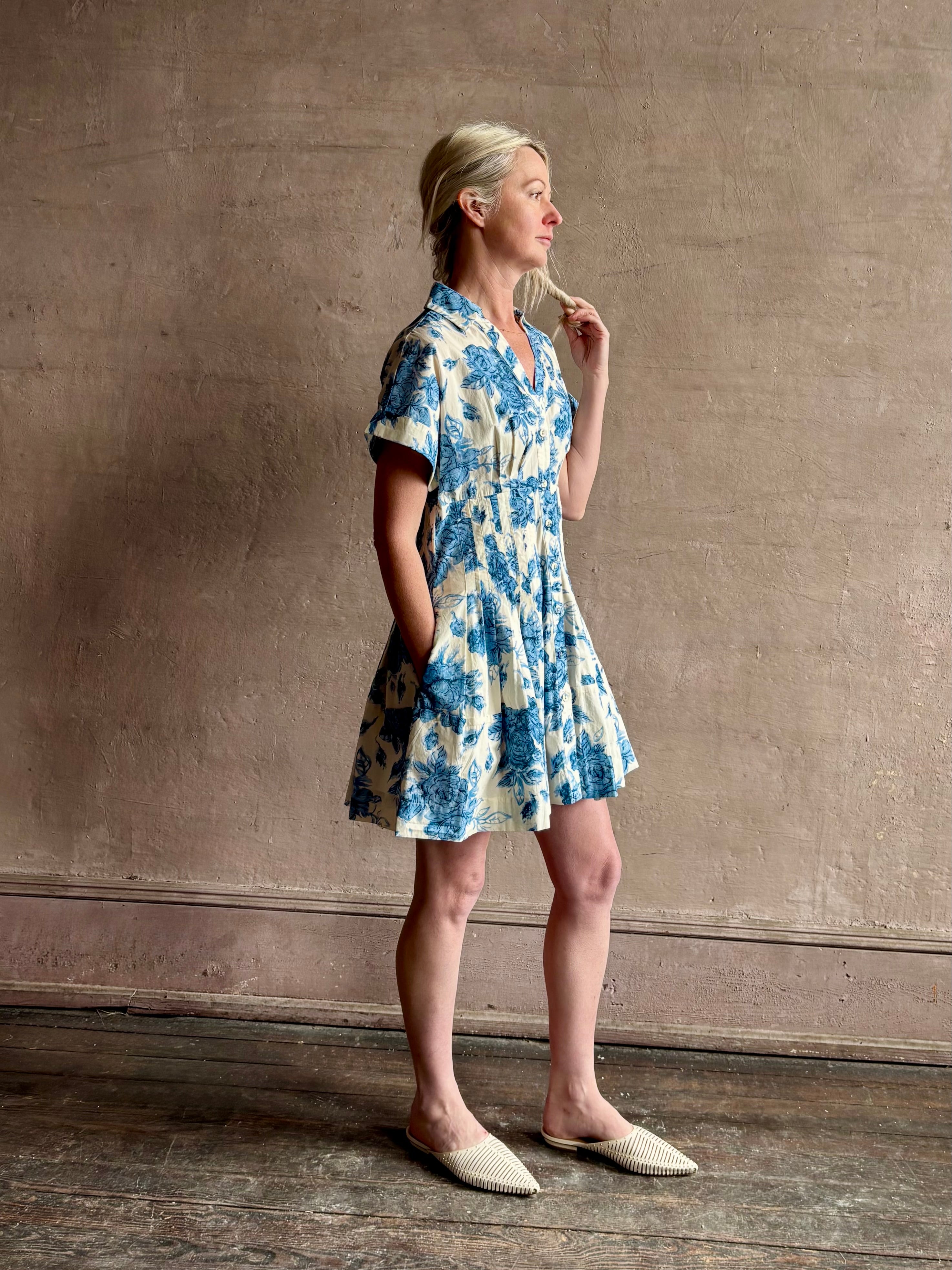 Image of woman wearing premium cotton poplin Cara Cara Nash Mini Dress in Tossed Floral Blue with v-neck short sleeves and pintucked waist detail