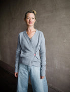 Image featuring a woman wearing the grey cashmere sweater by Cissa with a button front than can be worn multiple ways- crossed over  or as a cardigan.