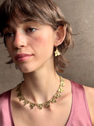 Woman wearing Hydrangea Collar Necklace from New Yok fine jewelry designer Emilie Shapiro is a statement  piece with Natural blue sapphires are individually embedded in warm, textured brass with artful exploration of form and movement handcrafted in USA