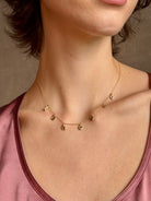 Woman wearing Mirage Cascade Diamond Necklace from New York fine jewelry designer Emilie Shapiro featuring seven dangling rose cut diamonds in 14k yellow gold exquisitely handcrafted in USA