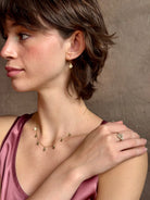 Woman wearing a White Sapphire statement Ring from contemporary fine jewelry designer Emilie Shapiro composed of three round white sapphires set in 14k yellow gold handcrafted in USA