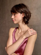 Woman wearing a White Sapphire statement Ring from contemporary fine jewelry designer Emilie Shapiro composed of three round white sapphires set in 14k yellow gold handcrafted in USA