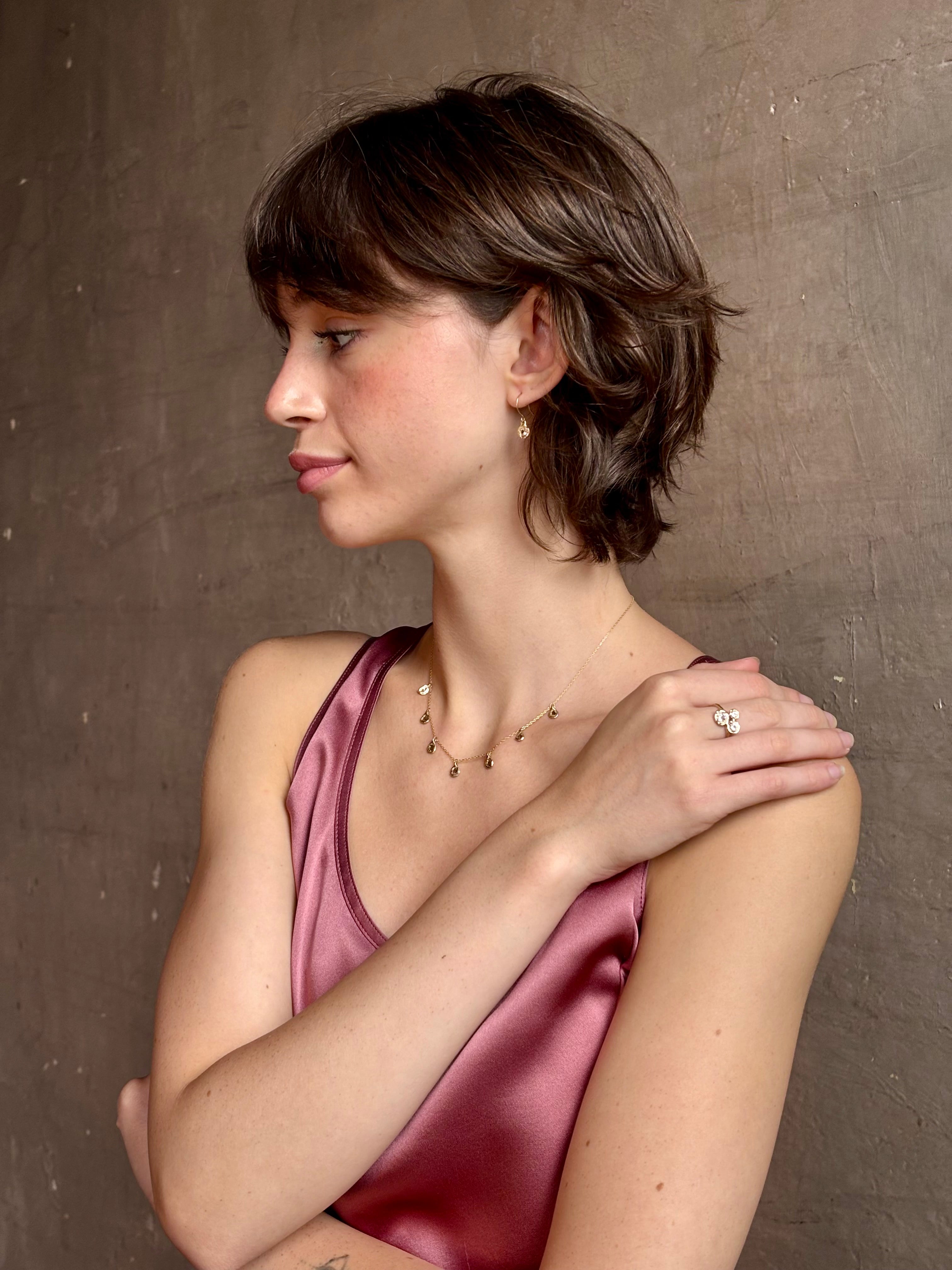 Woman wearing a White Sapphire statement Ring from contemporary fine jewelry designer Emilie Shapiro composed of three round white sapphires set in 14k yellow gold handcrafted in USA