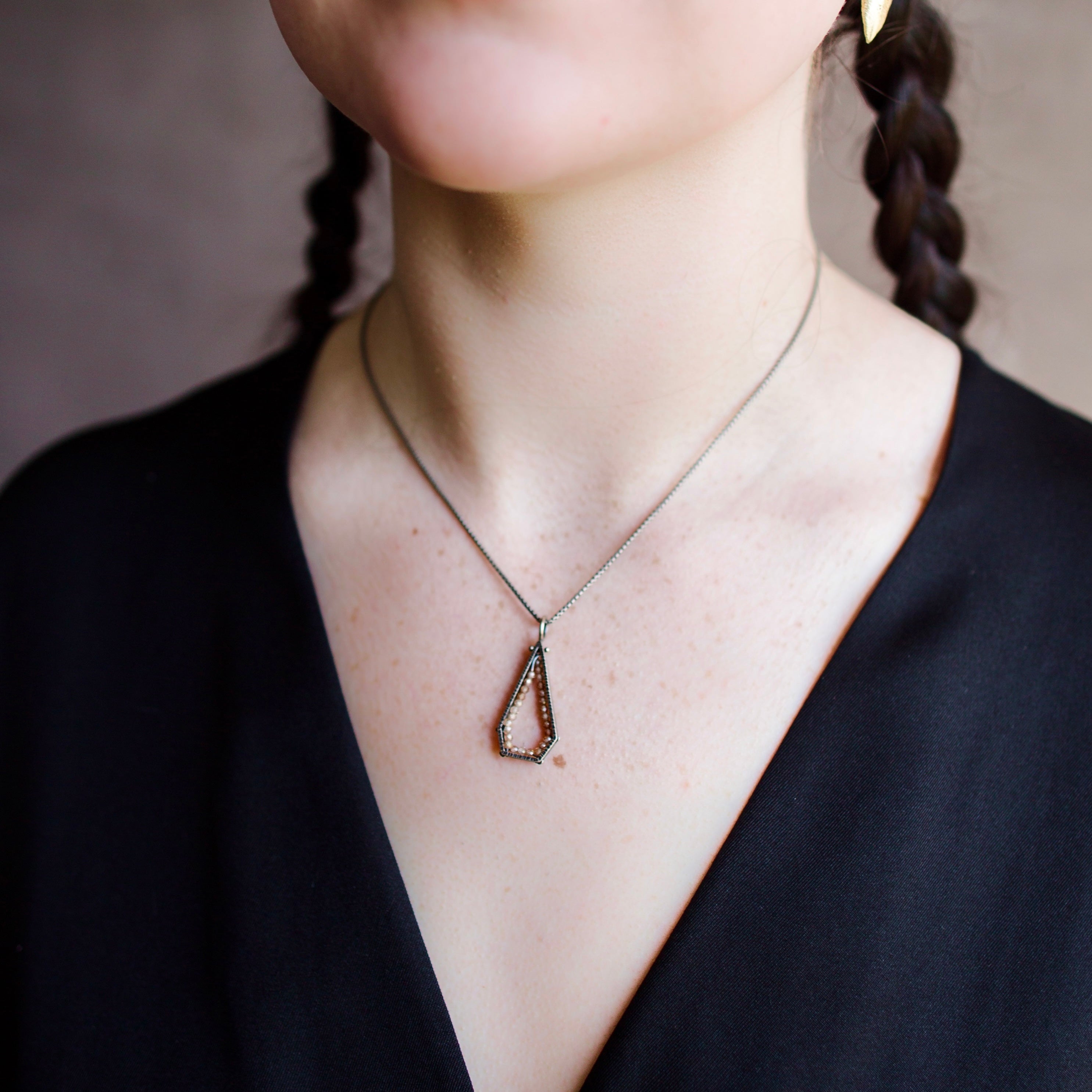 Woman wearing a sterling silver and champagne zircon geometric hexagon pendant necklace by North Carolina jewelry artist Erica Bailey handmade in USA