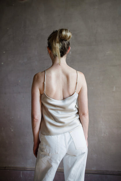 Image featuring a woman wearing the taupe Silk Satin Camisole from Enza Costa with a feminine scoop neckline, delicate straps, a gently flared hem and relaxed fit.