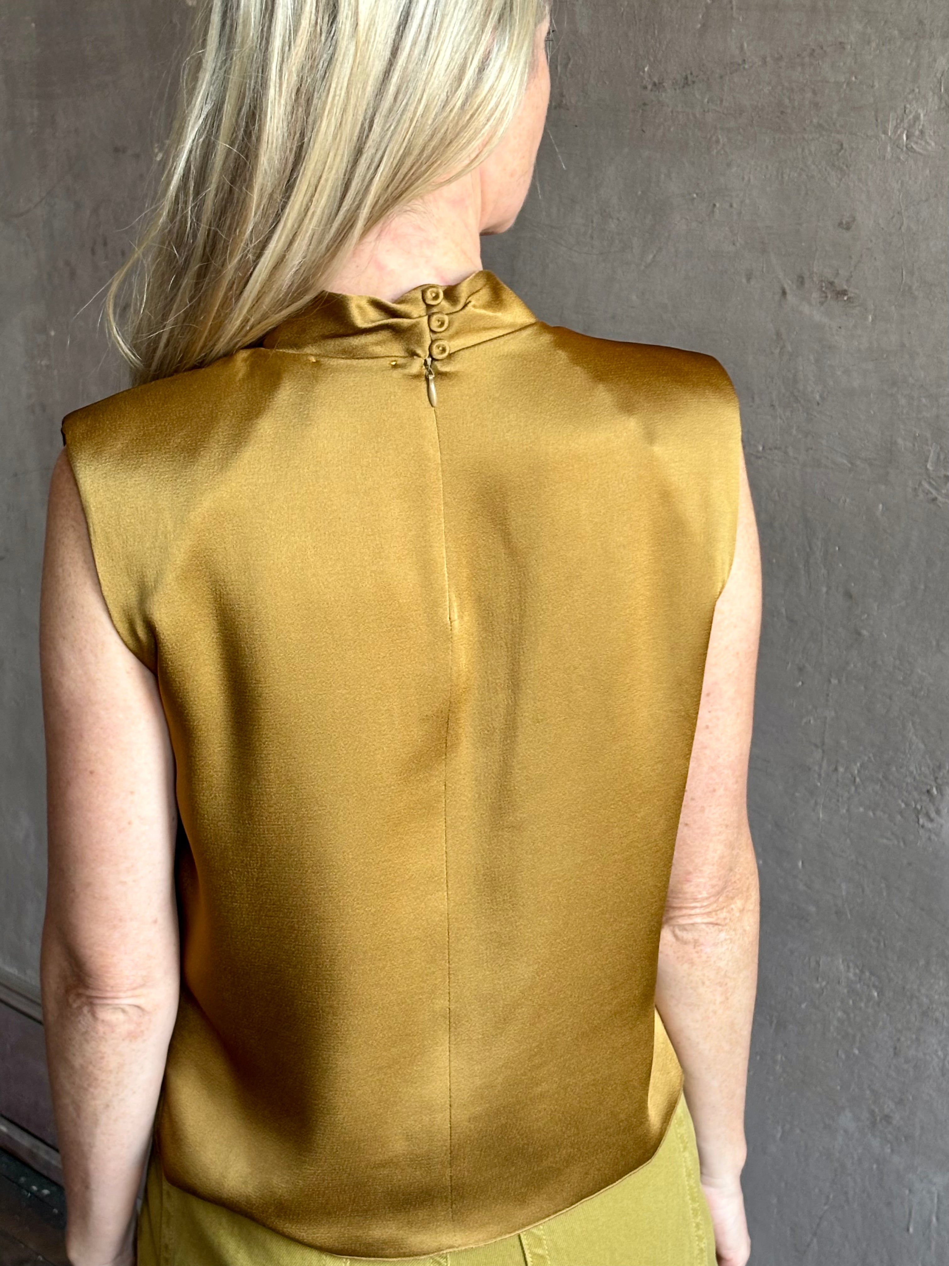 Image of mature woman wearing luxury Italian designer FORTE FORTE Envers Satin Crater-Neck sleeveless Shirt in matte Antique Gold 